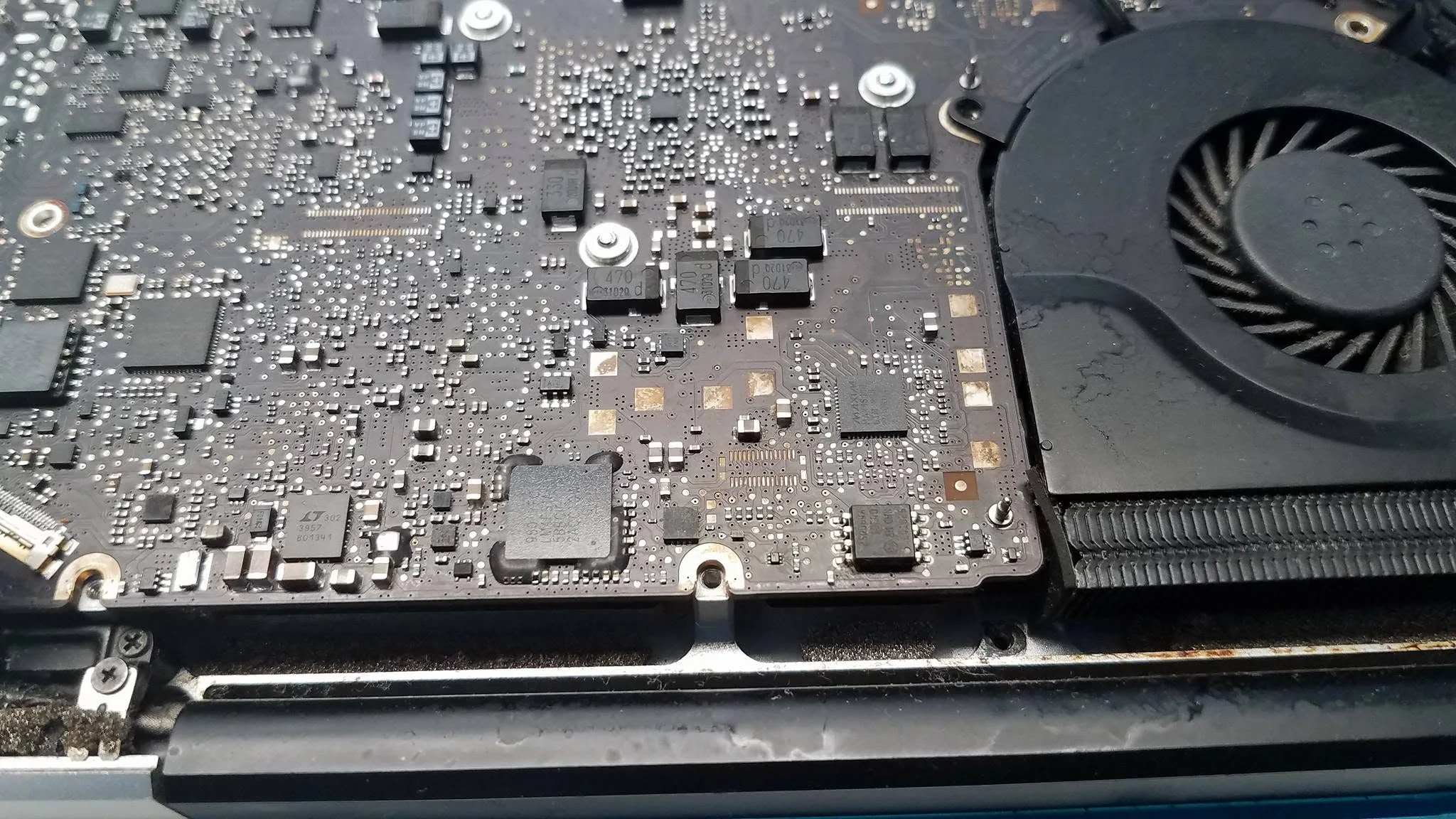 Close-up of a laptop motherboard during component-level repair
